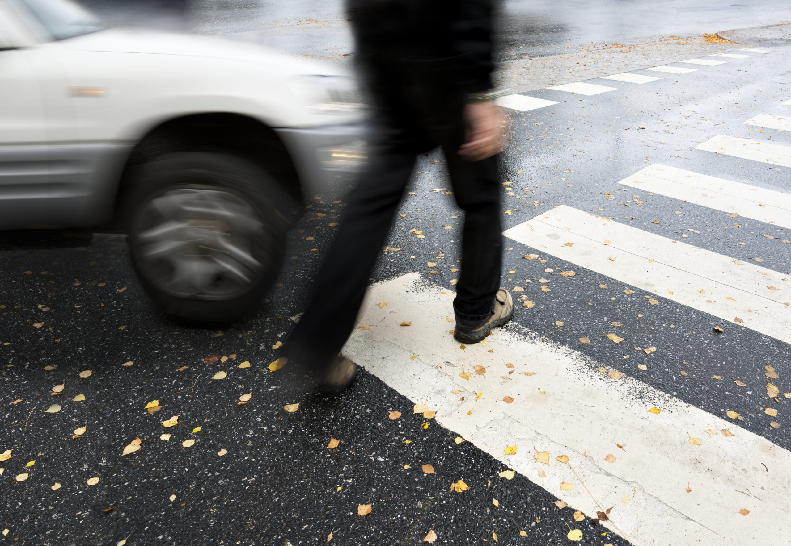 a person steps in front of a car while walking in a crosswalk, pedestrian accident