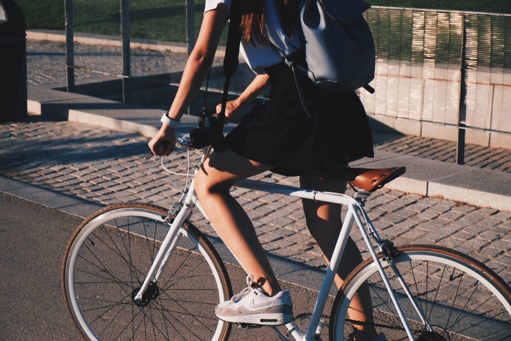 woman riding white rigid bike on her way to work. 