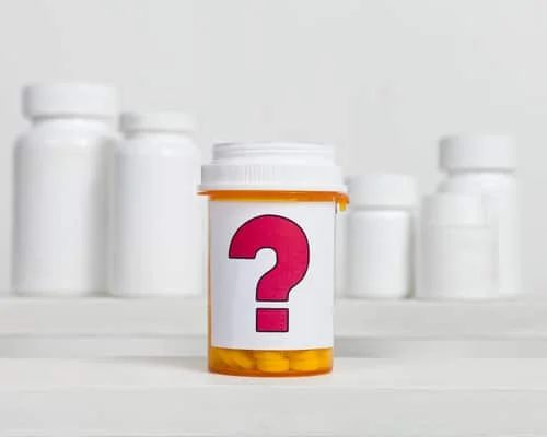 a prescription bottle with a large question mark for the label