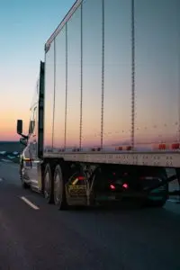 the side of a semi truck driving down a highway