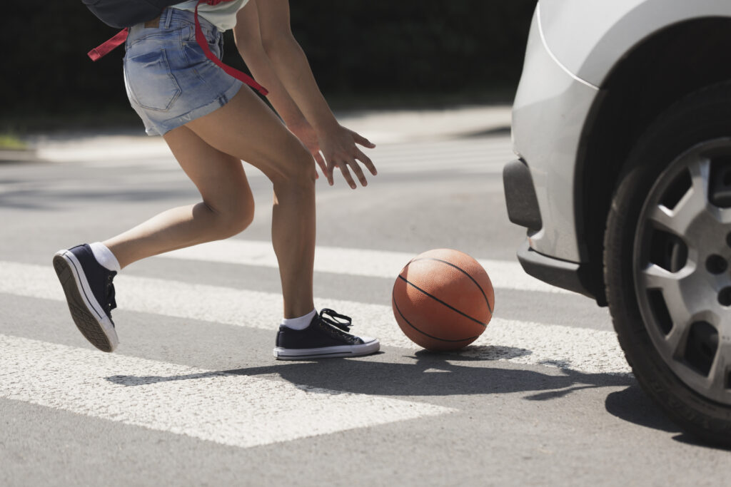 girl catching a basketball in pedestrian accident scene