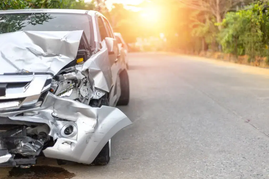 a silver car with heavy damage to the front end sits idle on the side of the road after a car accident in Virginia.