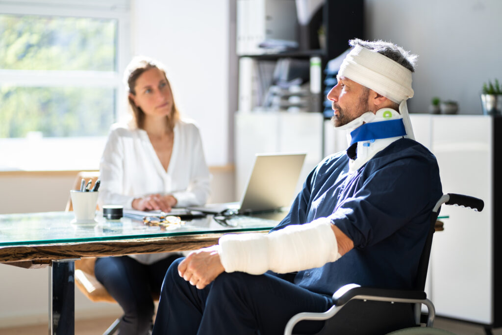 a heavily bandaged accident injury victim in a wheelchair speaks with his Virginia Beach personal injury lawyer about damages he can sue for.
