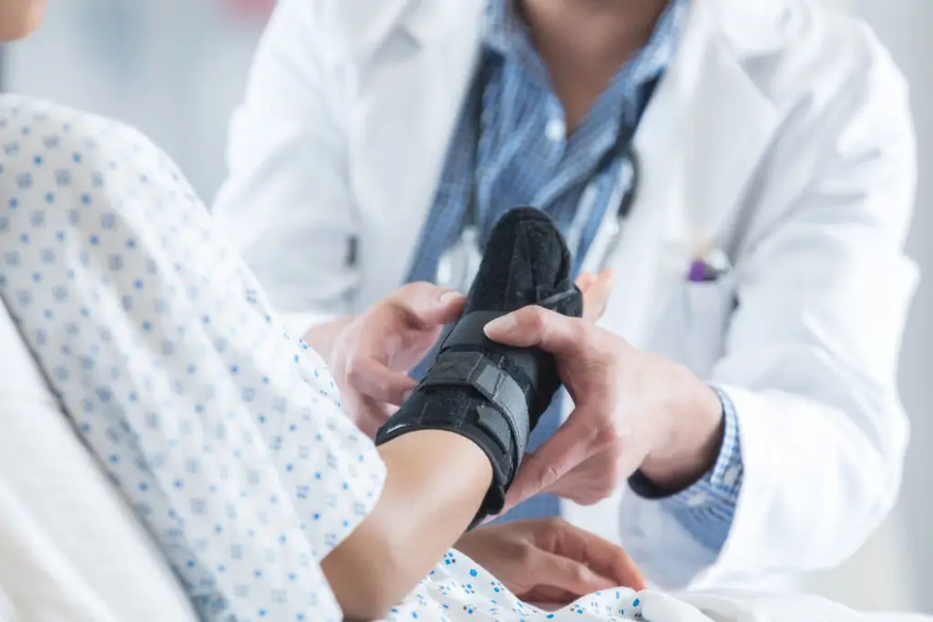 male doctor places an arm brace on a patient's sprained wrist. personal injury theme