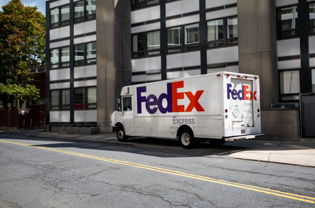 a FedEx delivery truck parked outside an office building.