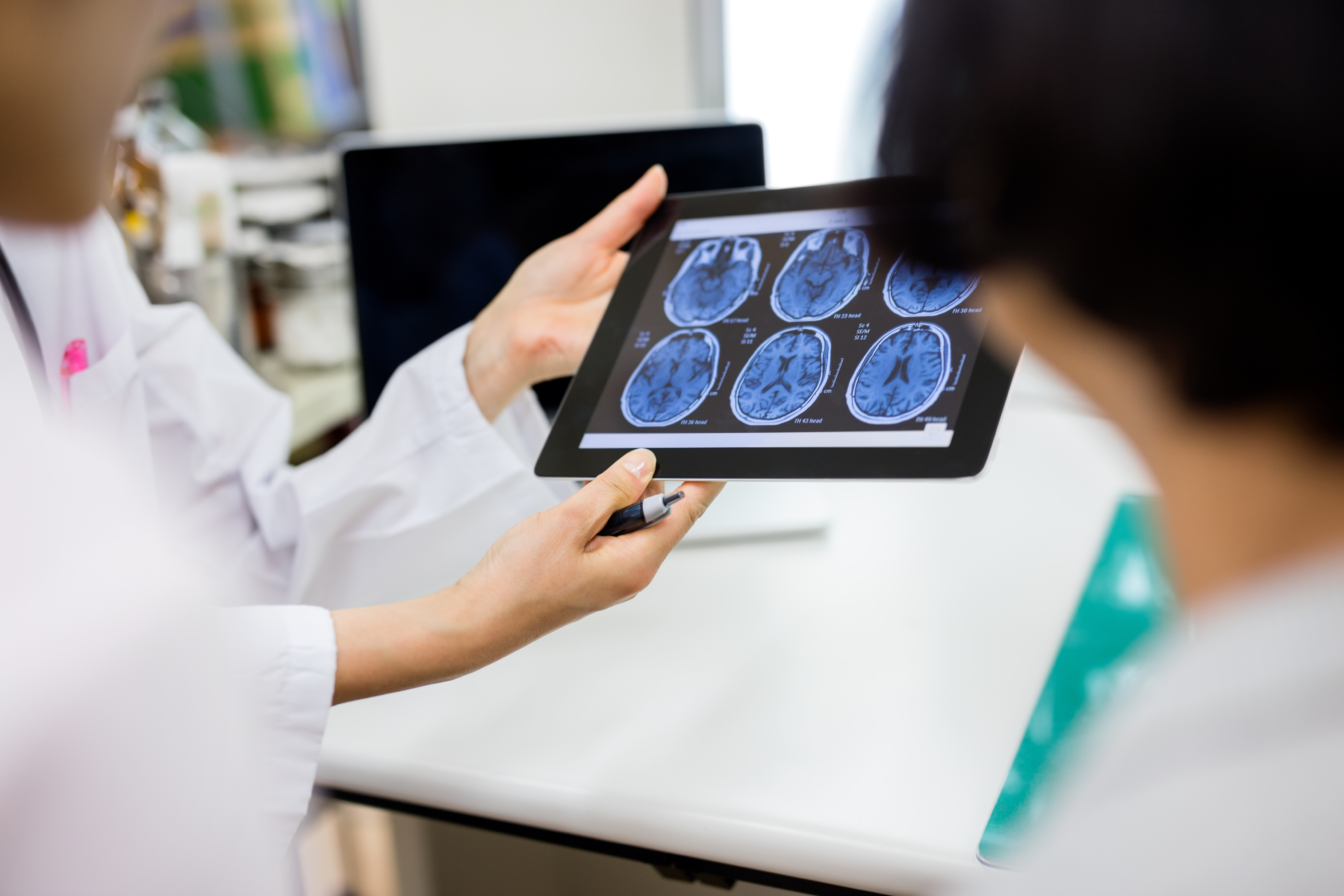 Doctor and patient using digital tablet to review brain injury scans post car accident