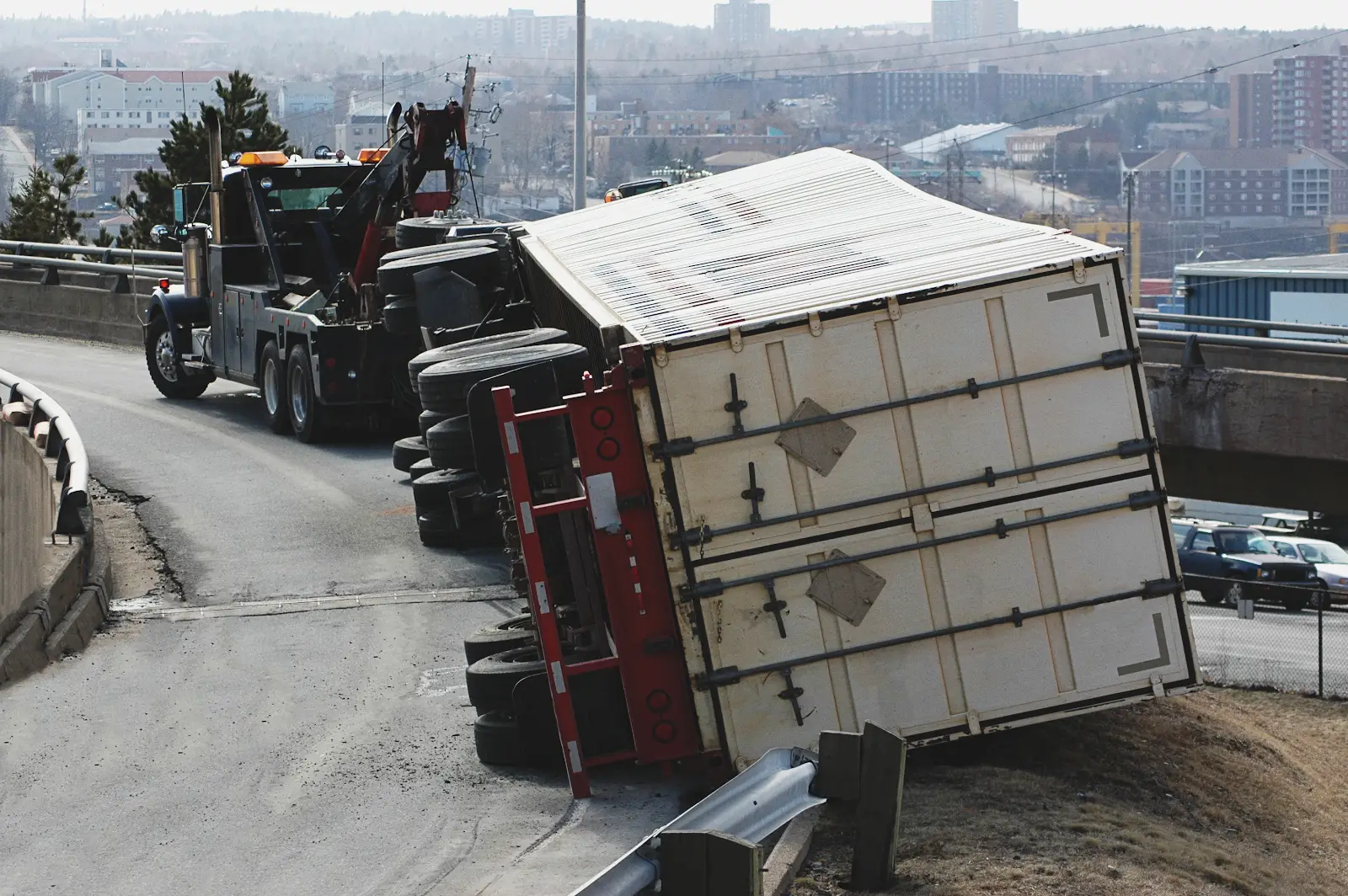 truck accident causing catastrophic injuries on the highway, truck flipped over getting help from a tow truck