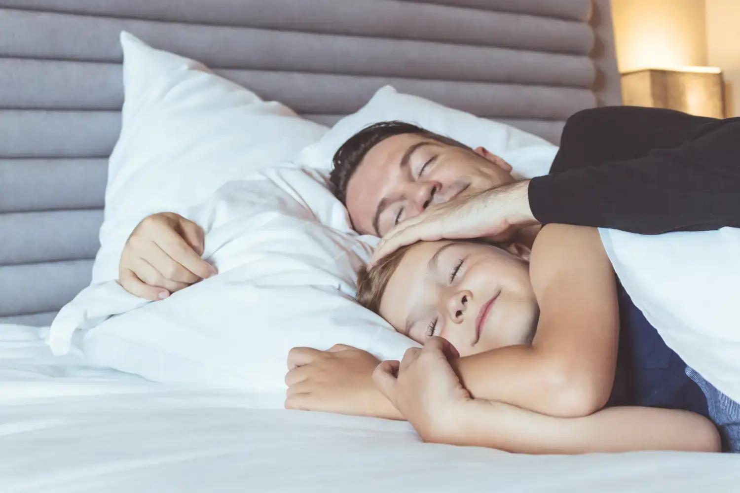 father and son sleeping in bed
