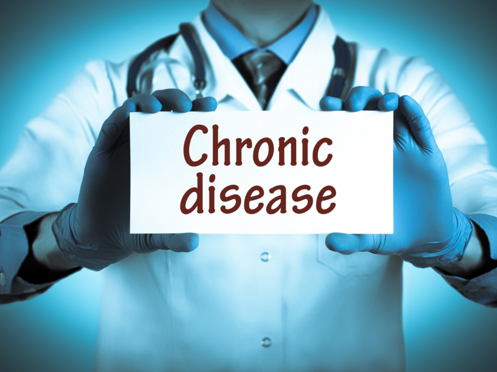 man holding up a sign that says chronic disease