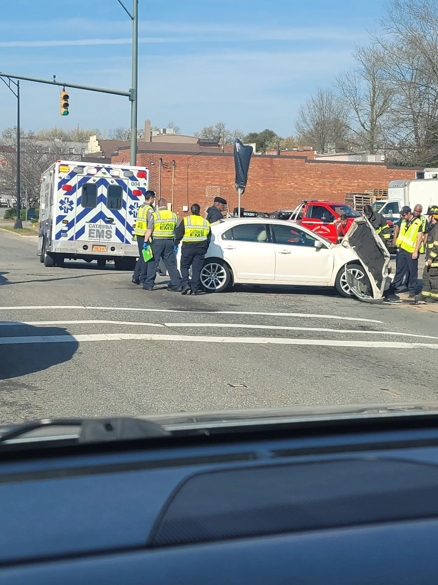 An ambulance and first responders surround a vehicle that was just in an accident.