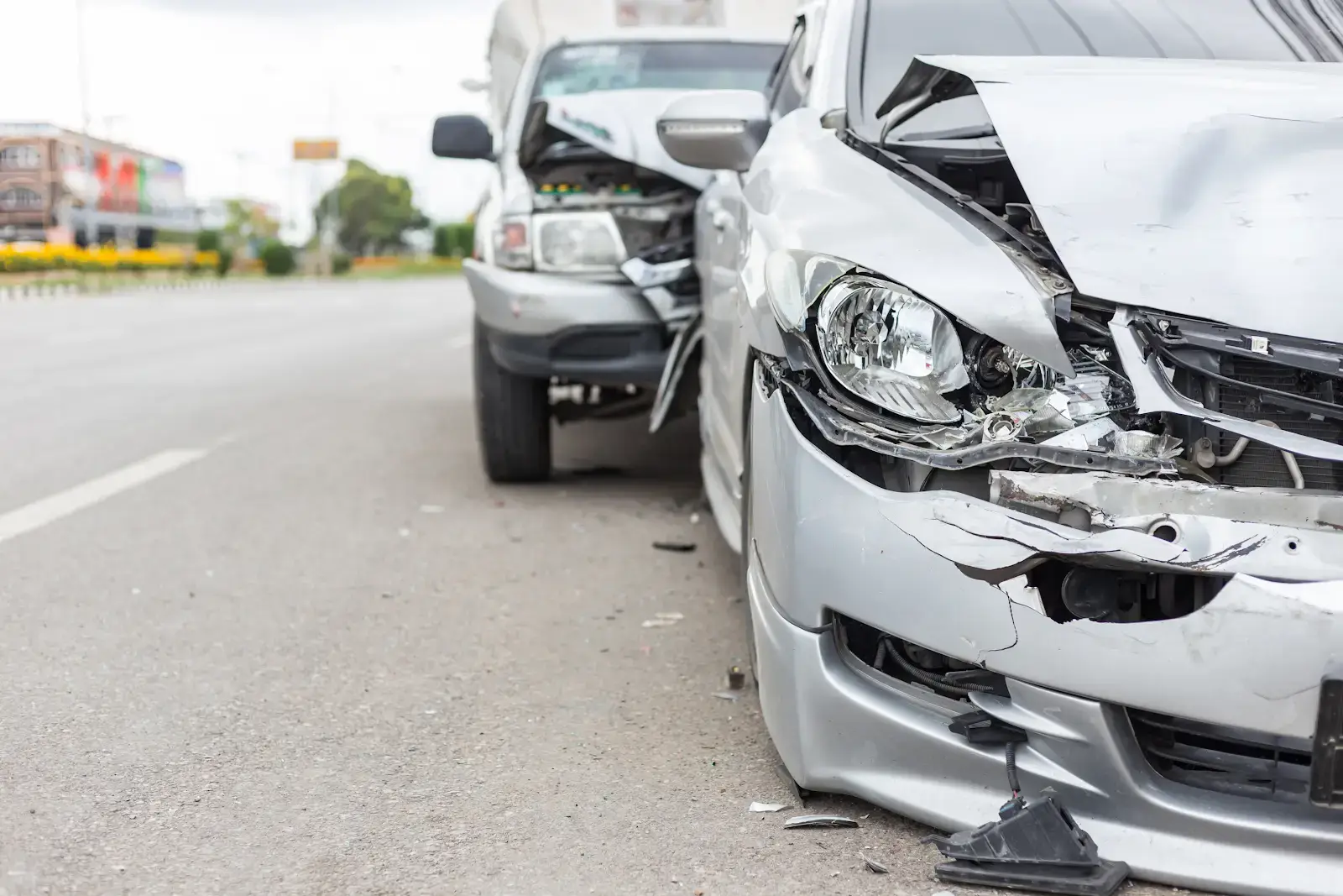 A close up view of the hood of a silver car that was in a multi-vehicle accident after being rear-ended on the highway.