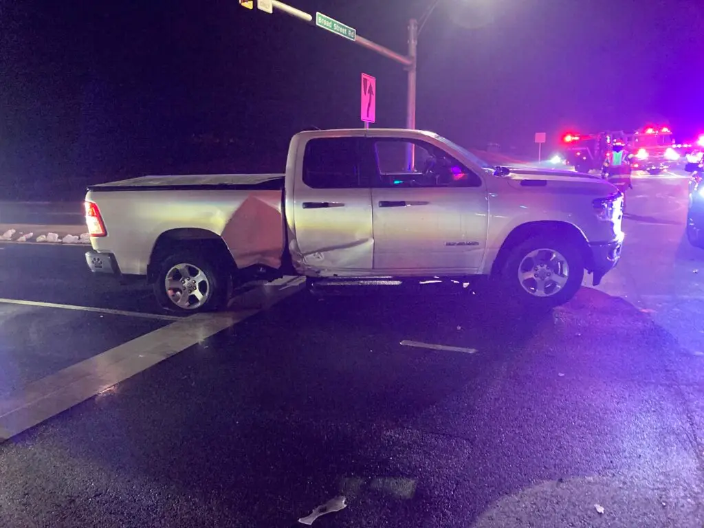 A pickup truck after a side-impact collision at night in Virginia. Police are on the scene to complete an accident report of the event.