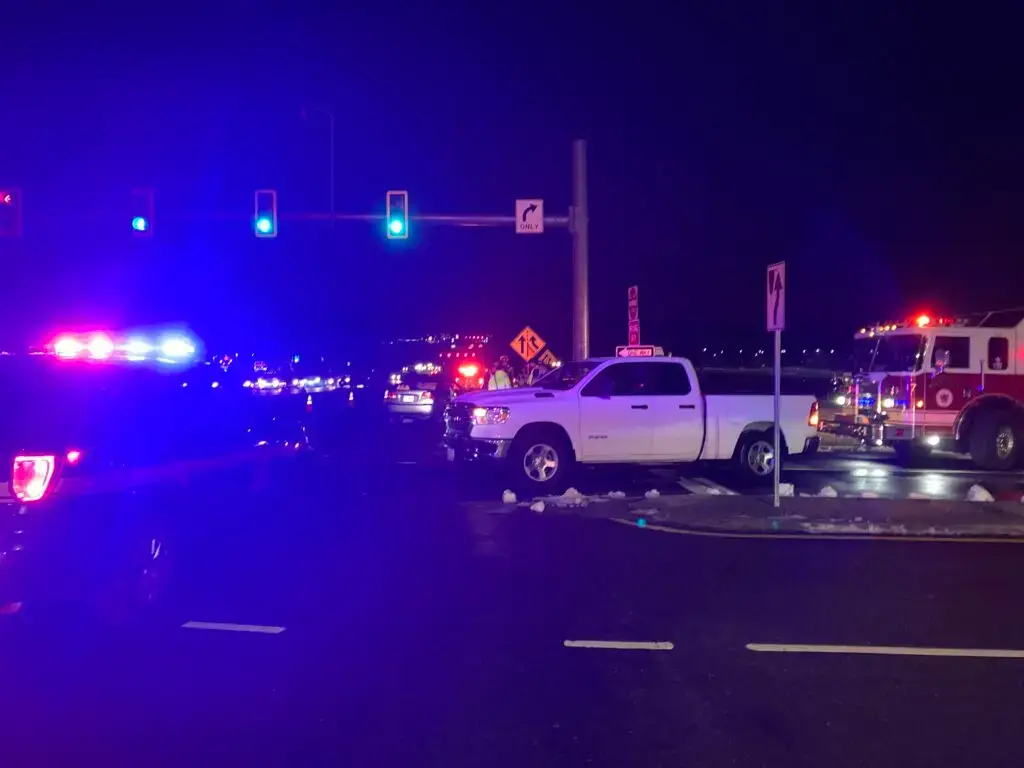 A damaged pickup truck after an accident at an intersection on Broad Street in Richmond, VA at night, Police and Fire trucks are on the scene.