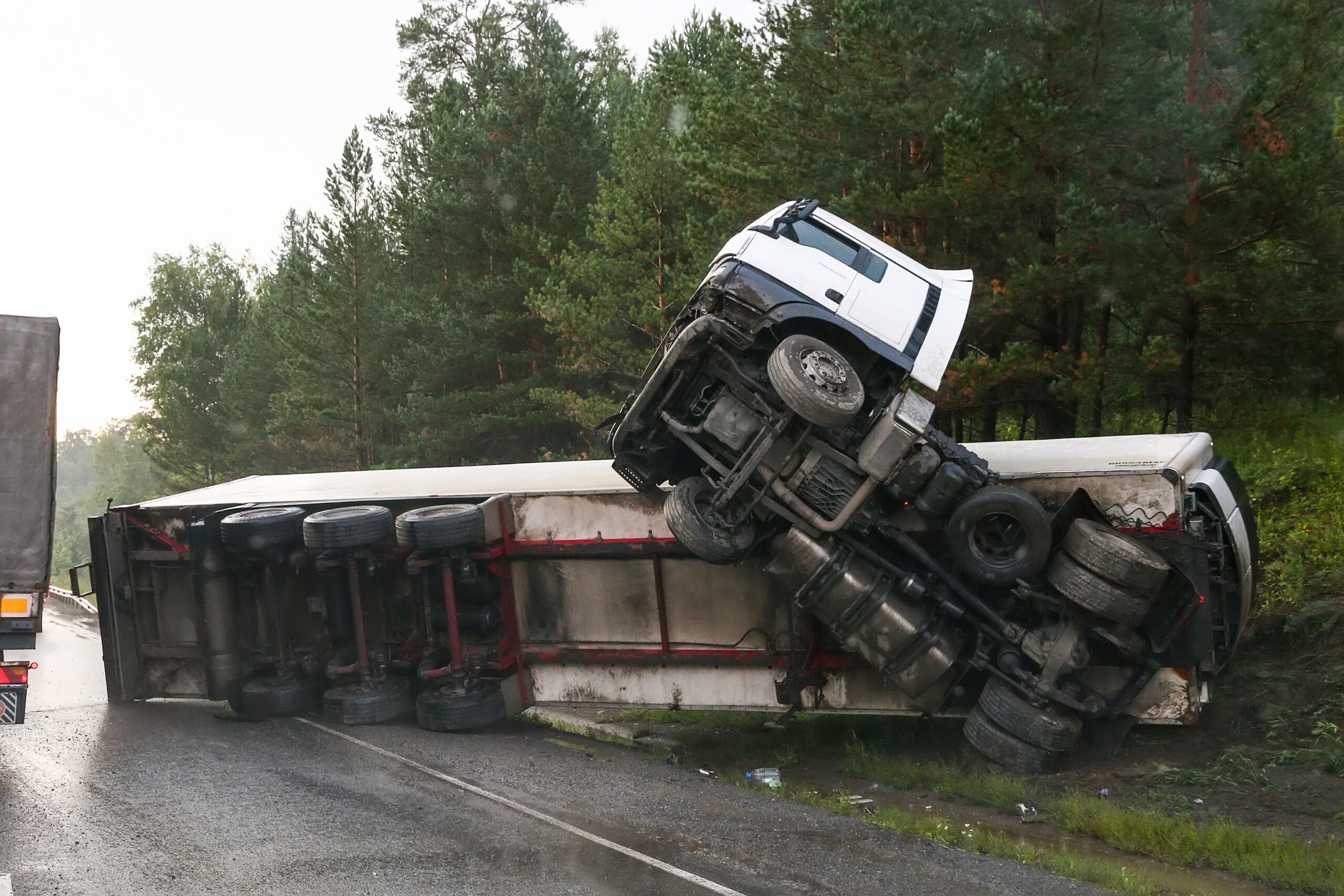 A rolled over semi-truck on the side of the highway after a jackknife truck accident.