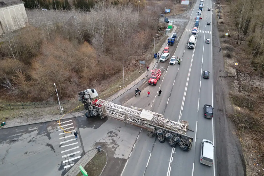 A transport truck blocks traffic in both ways after a rollover accident leaves it turned over on its side across four lanes of traffic. 