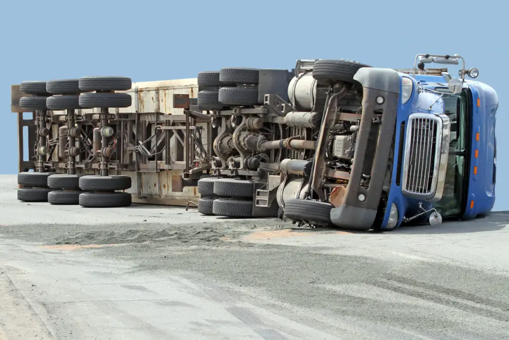 A semi-truck that had a rollover accident after hitting some soft ground and tipping over. 