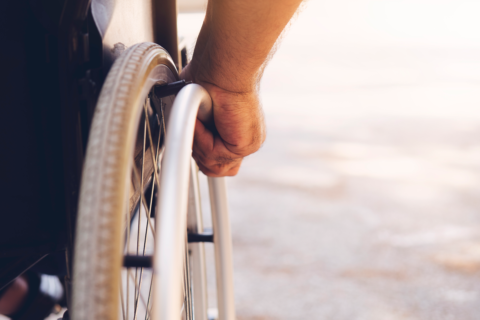 man in a wheel chair rolling down a hallway