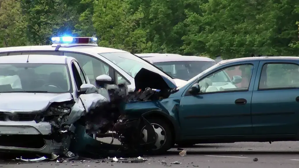 a green car crashed into the side of a silver car.