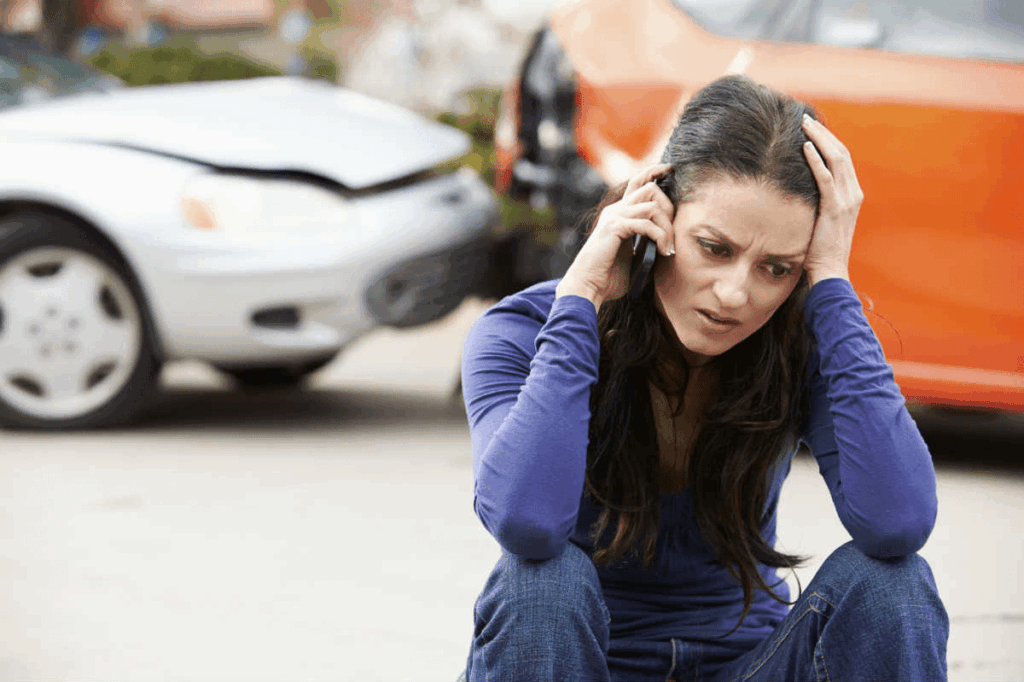 A woman speaks on the phone after she is in a car accident.