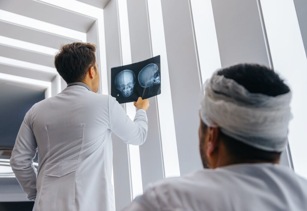 A doctor reviews imaging with a patient who has vision problems after a car accident.